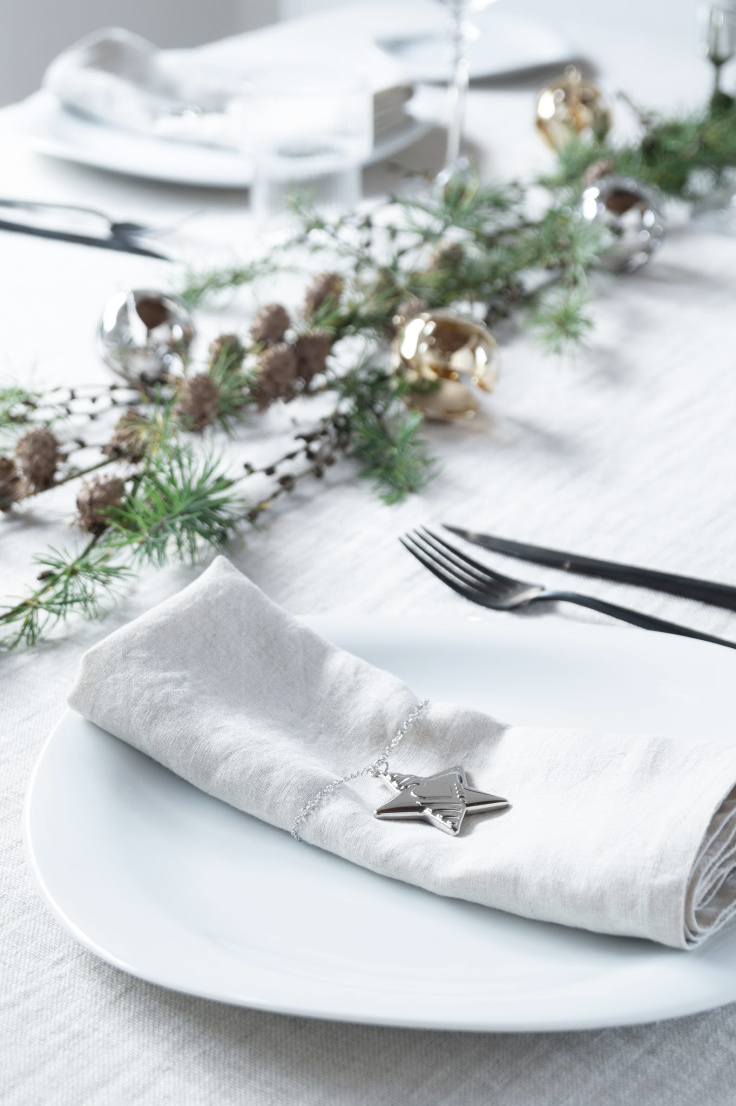 close up of Christmas dinner table setting with silver Georg Jenson start Christmas decoration