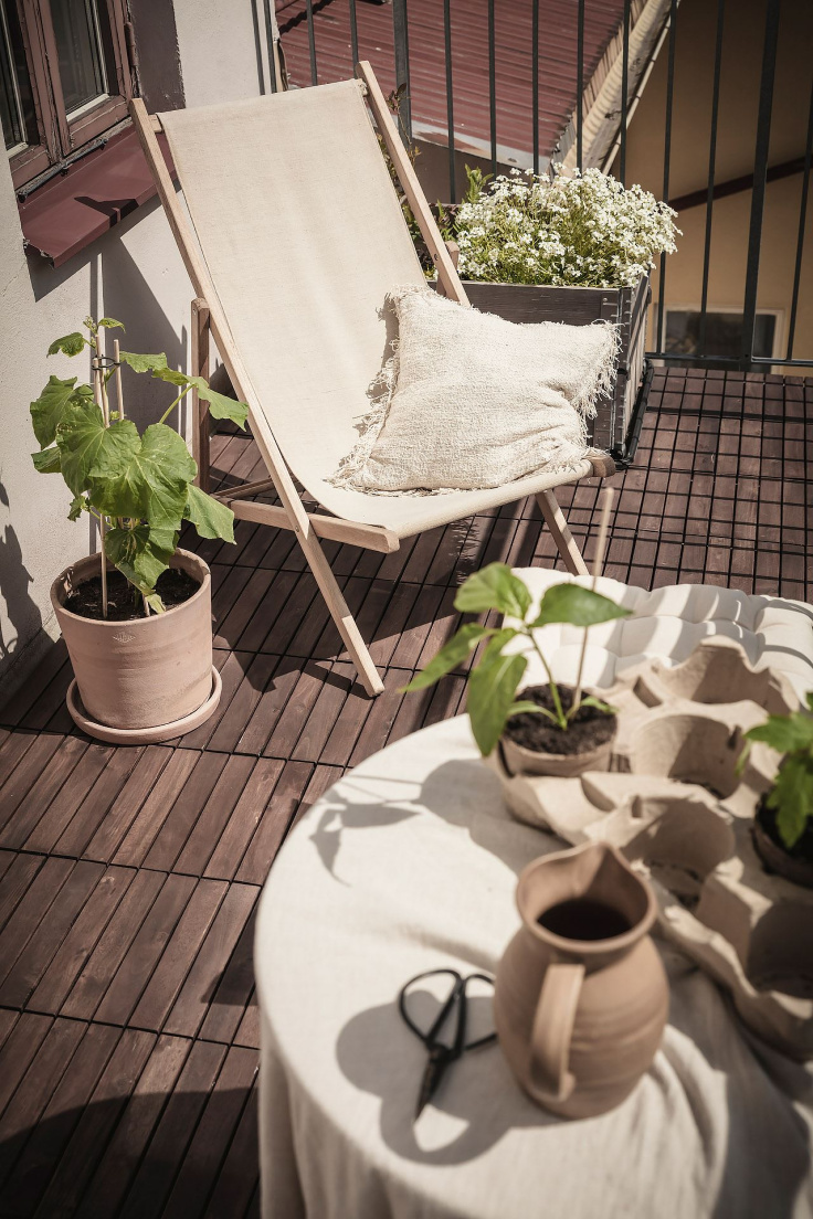 SMALL BALCONY WITH DECK CHAIR AND GREEN PLANTS