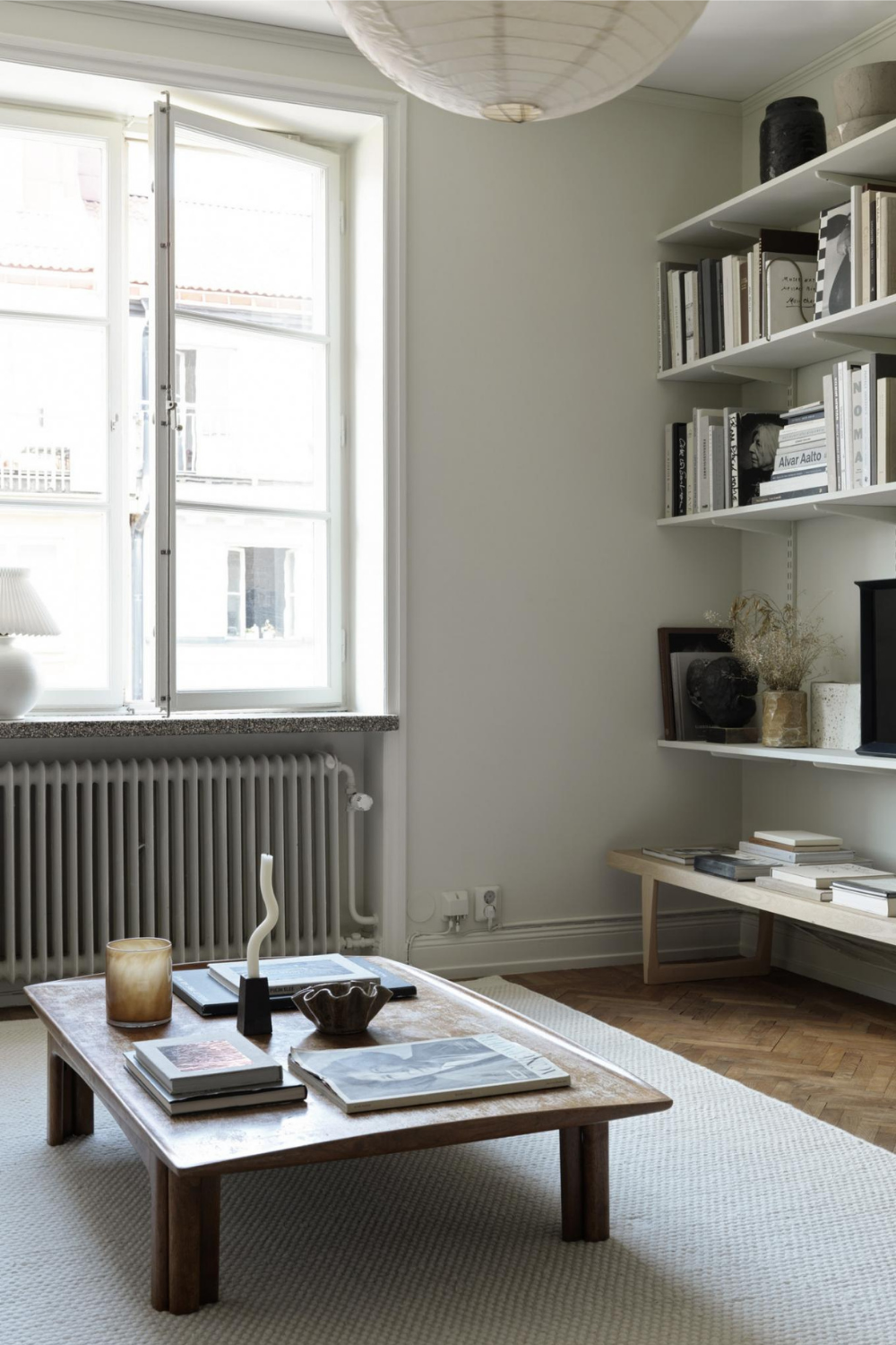 beige interior design ideas for the living room using open shelves for display and modern ceramic sculptures