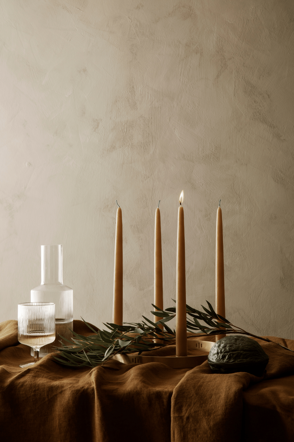 Nordic inspired table setting with glasses and natural coloured candles, perfect for a Scandinavian table setting